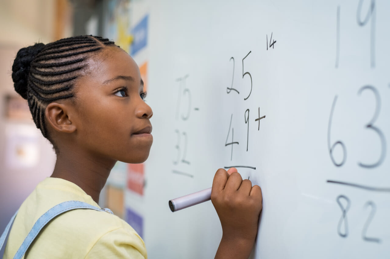 Black student solving math problem, theGrio.com