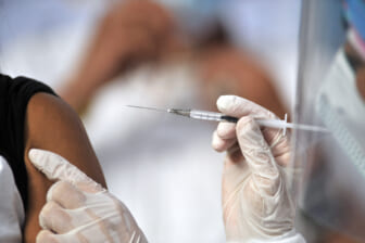 US hits 70% vaccination rate — a month late, amid a surge
