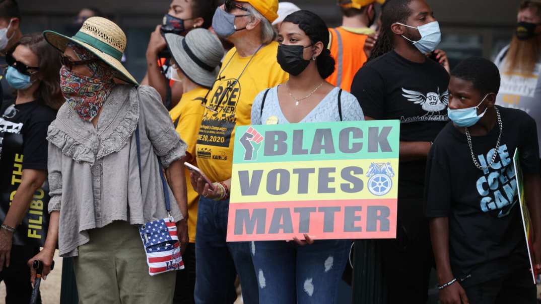 A group of protesters with a "Black Votes Matter" sign