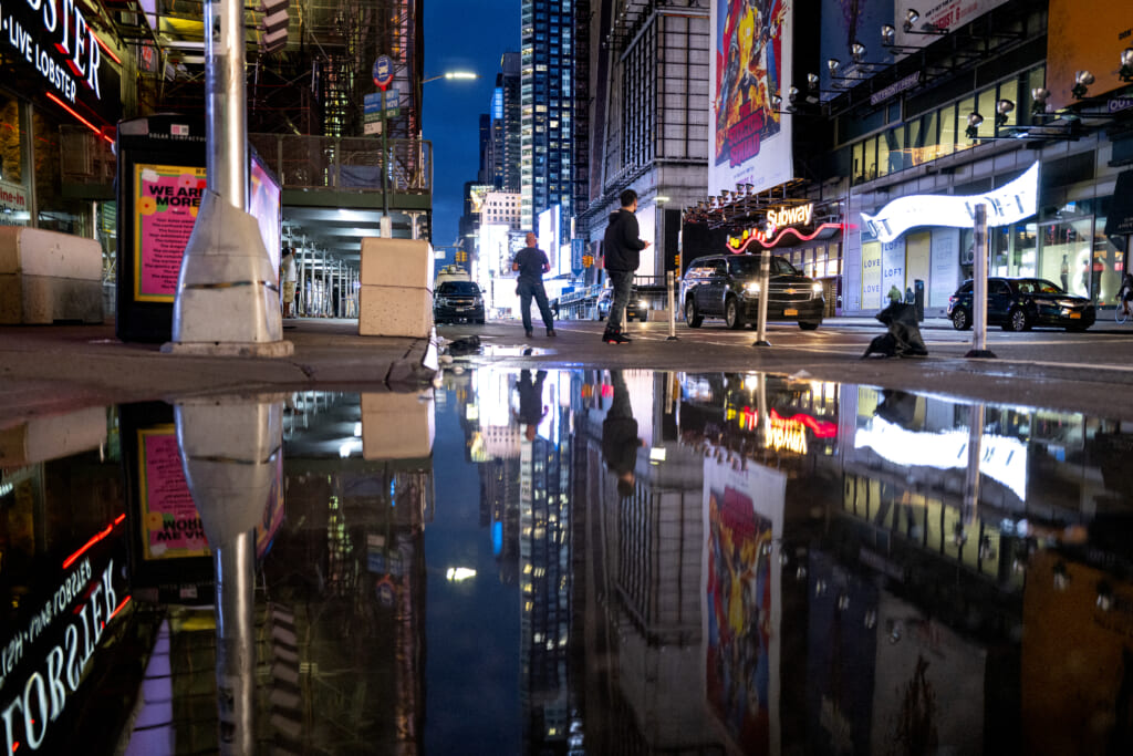 The lights of Times Square in New York reflected in standing water