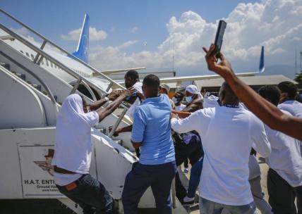 Deported Haitians try to rush back into plane amid anger