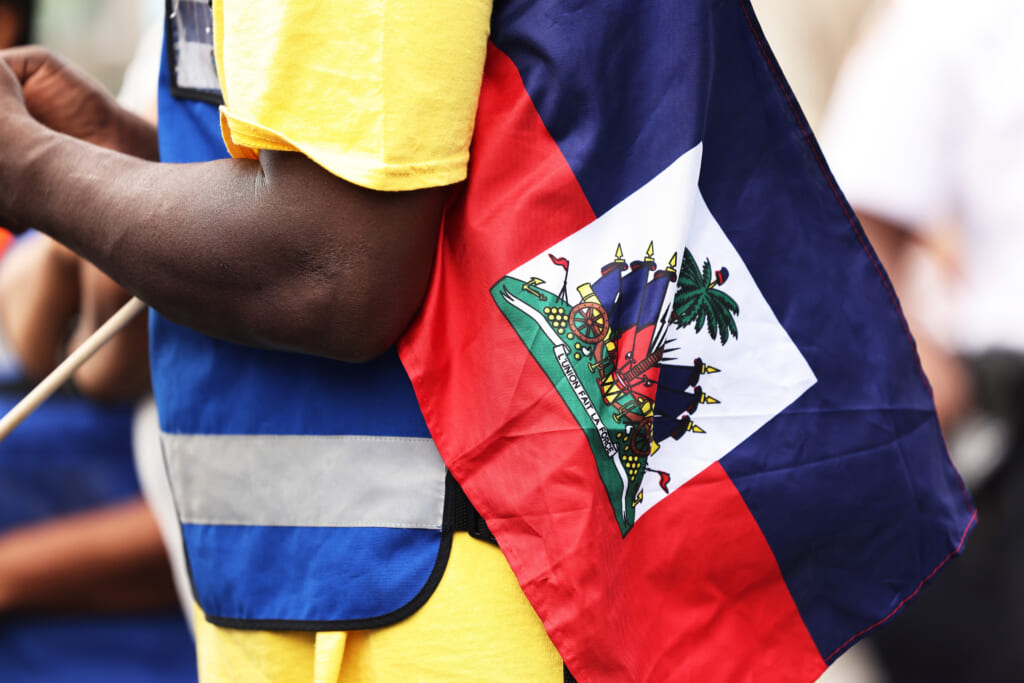 A man holds a Haitian flag