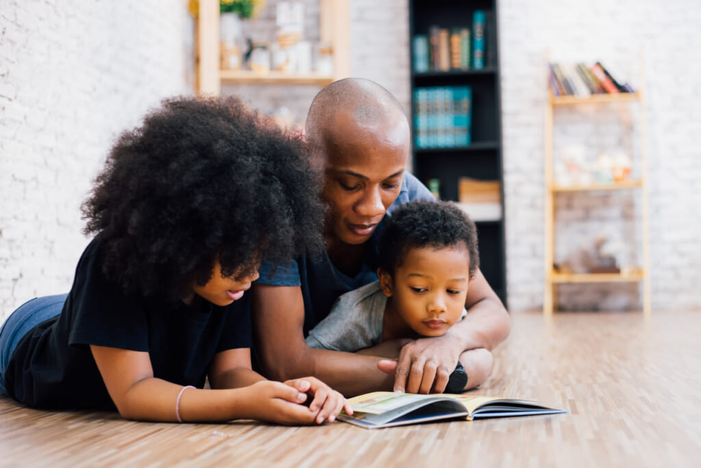 Black parents reads book to child