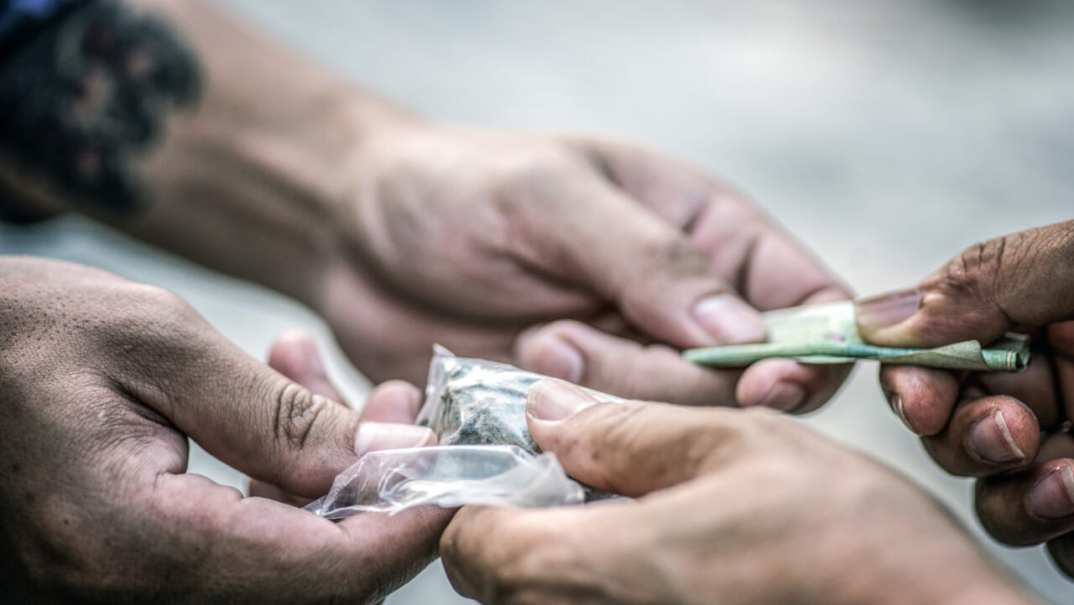 Hands of people completing a drug transaction