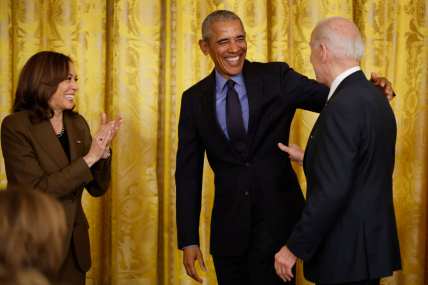 Vice President Kamala Harris applauds beside former President Barack Obama who reaches toward President Joe Biden