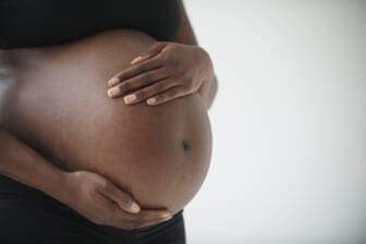 pregnant Black woman holding belly theGrio.com
