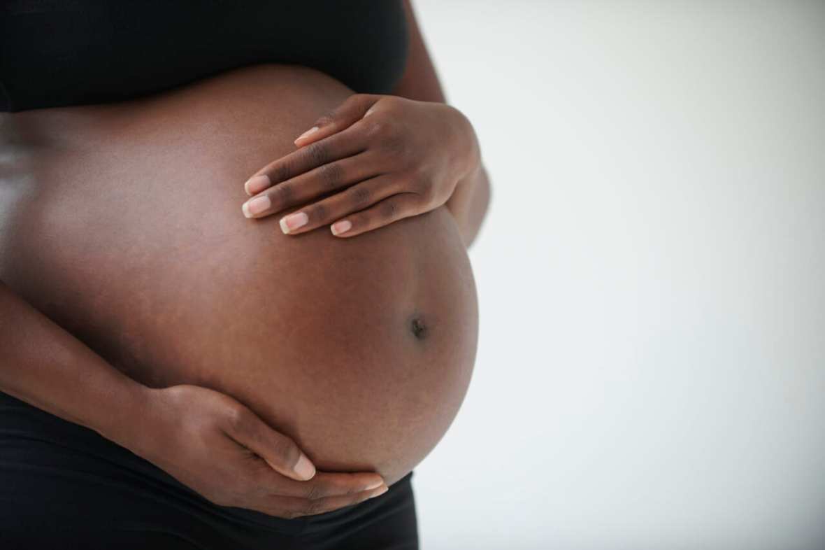 pregnant Black woman holding belly theGrio.com