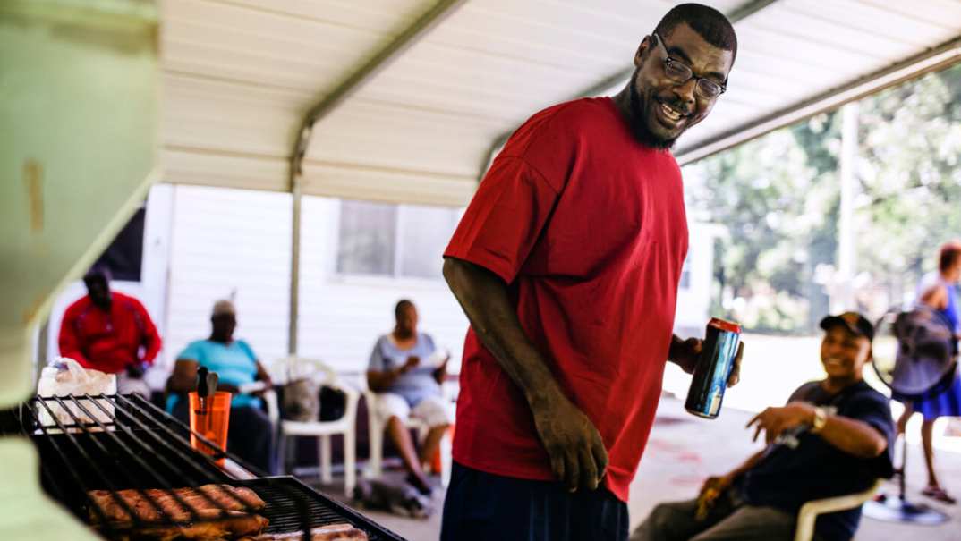 A man stands near a barbecue grill