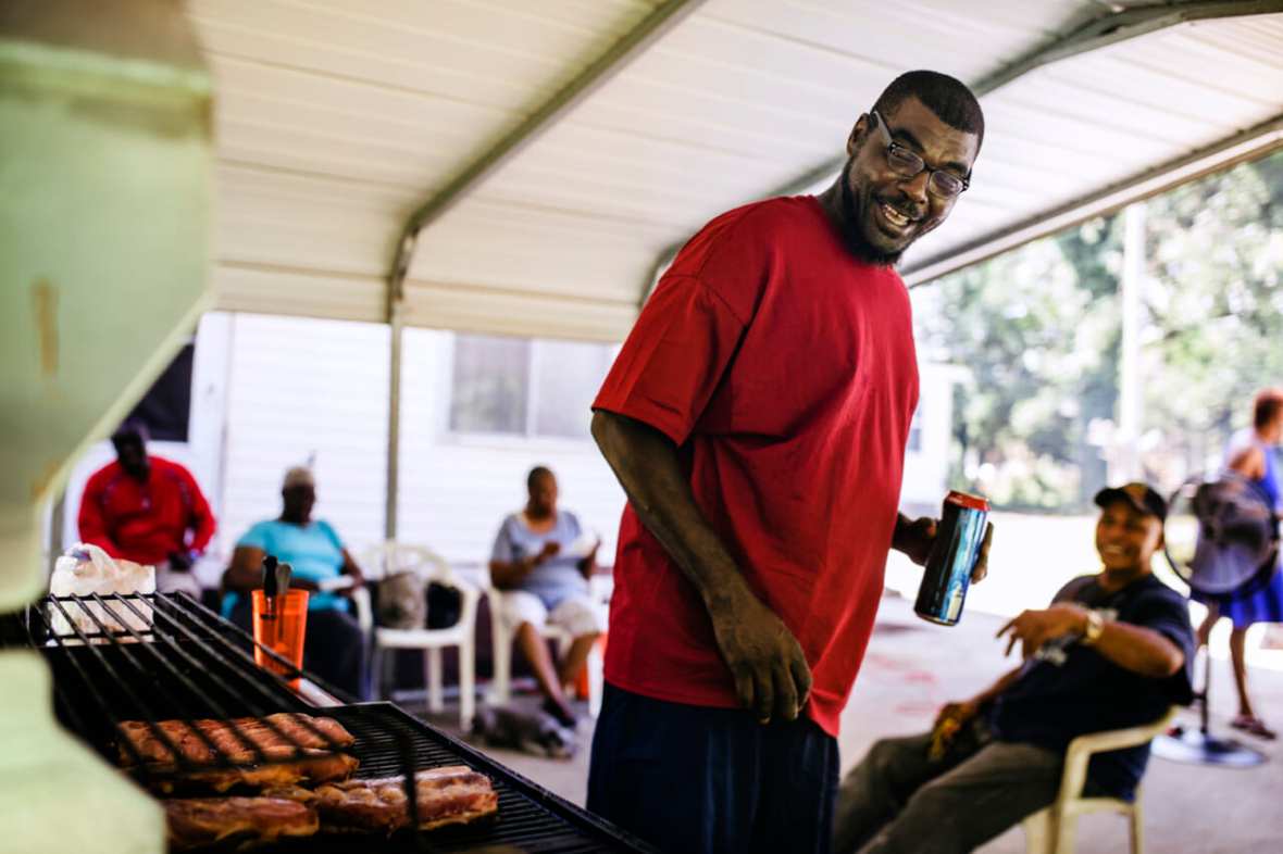 A man stands near a barbecue grill