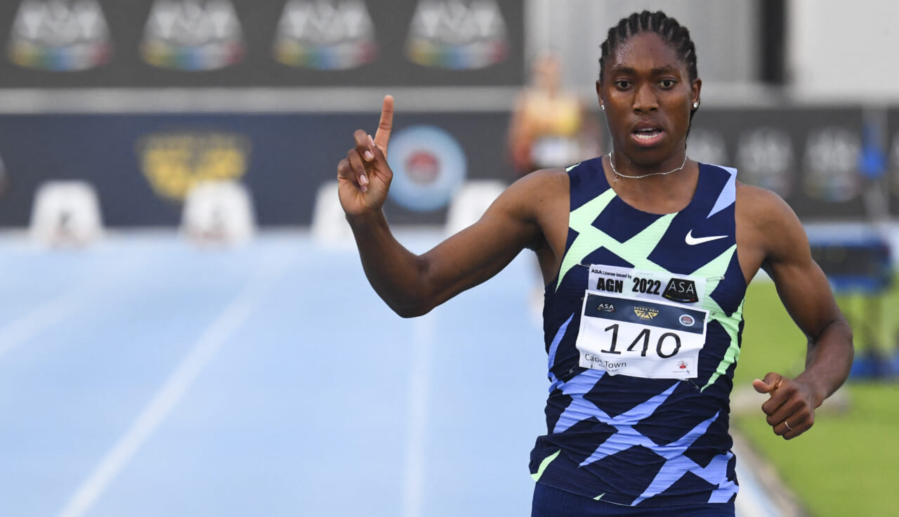 South African track star Caster Semenya points upward as she rounds the track