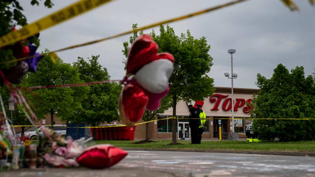 People gather at the scene of a mass shooting at Tops Friendly Market