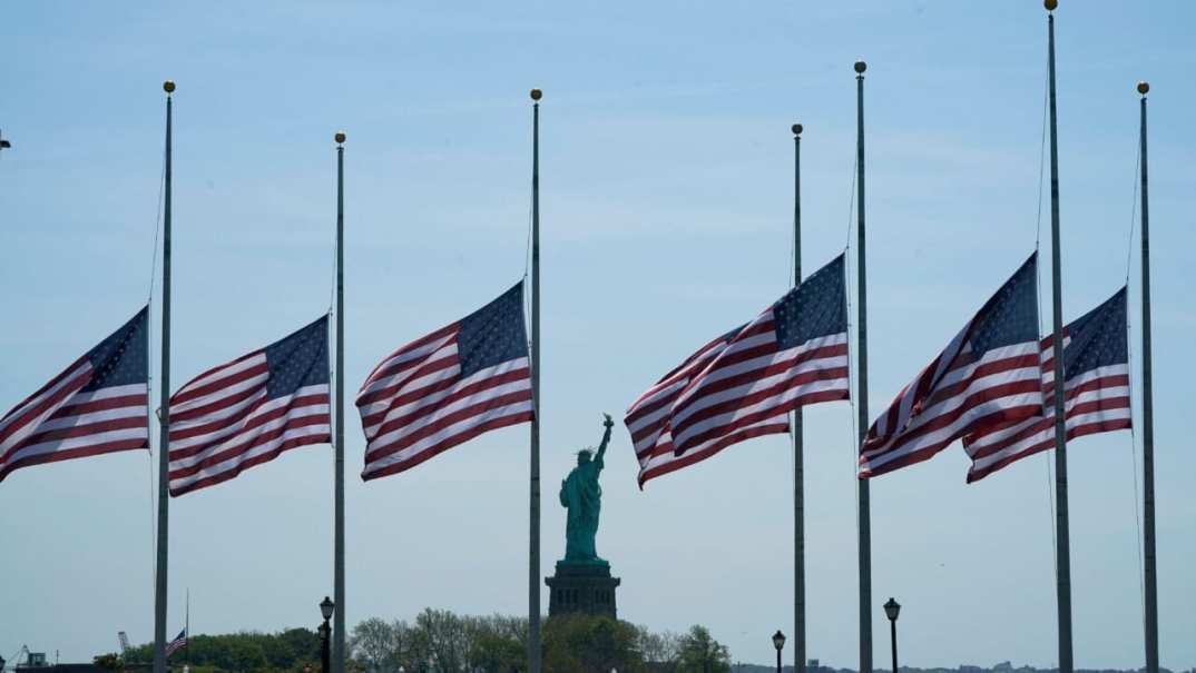 U.S. flags, across New York Bay from the Statue of Liberty, fly at half-staff
