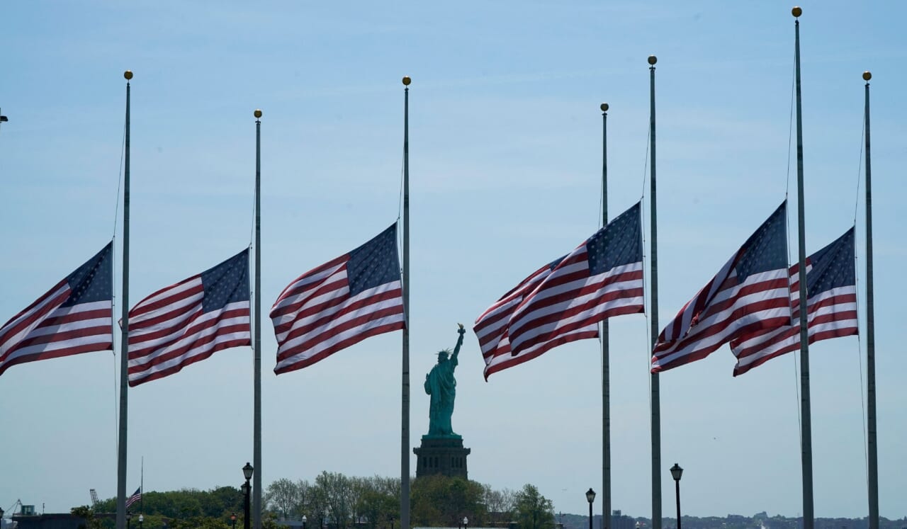 U.S. flags, across New York Bay from the Statue of Liberty, fly at half-staff