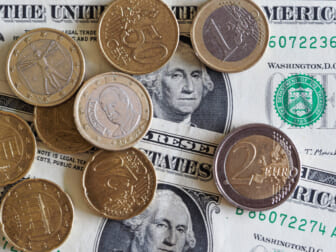 Coins and dollars show the comparison of the euro to the dollar today