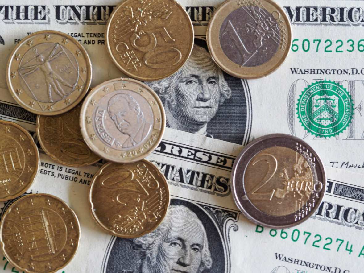 Coins and dollars show the comparison of the euro to the dollar today