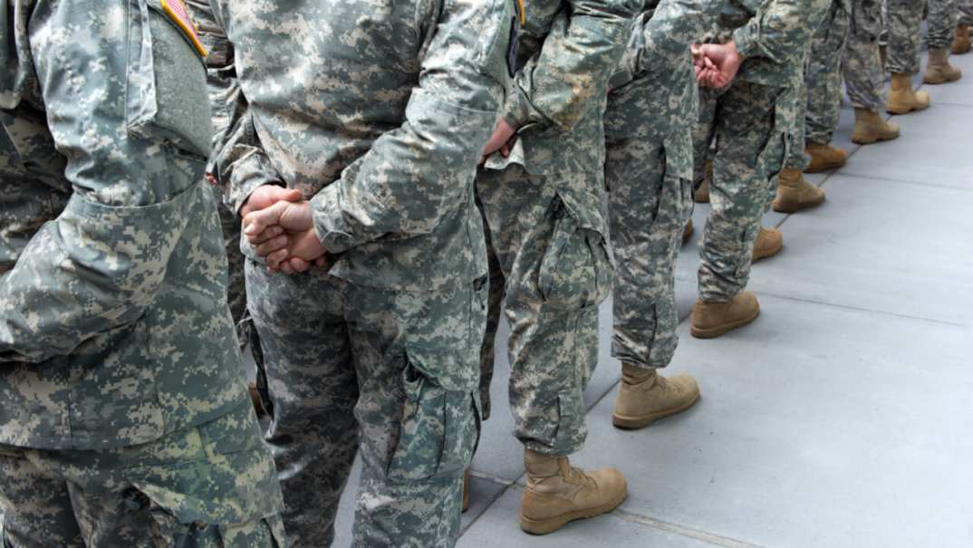 A line of soldiers wearing camouflage