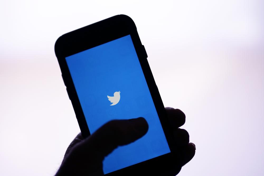 An iPhone with the Twitter bird logo on the screen