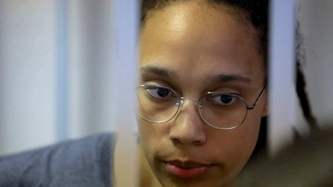 WNBA star and two-time Olympic gold medalist Brittney Griner stands in a cage in a courtroom in Russia