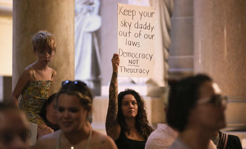 Demonstrators stand outside the House chamber