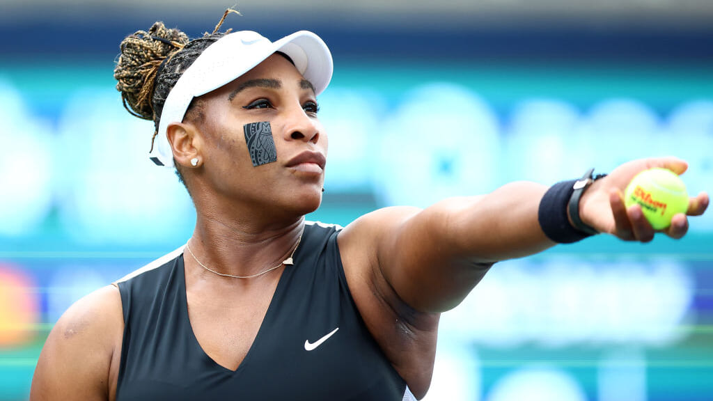 Tennis star Serena Williams holds a tennis ball while preparing for a serve, thegrio.com, famous black athletes