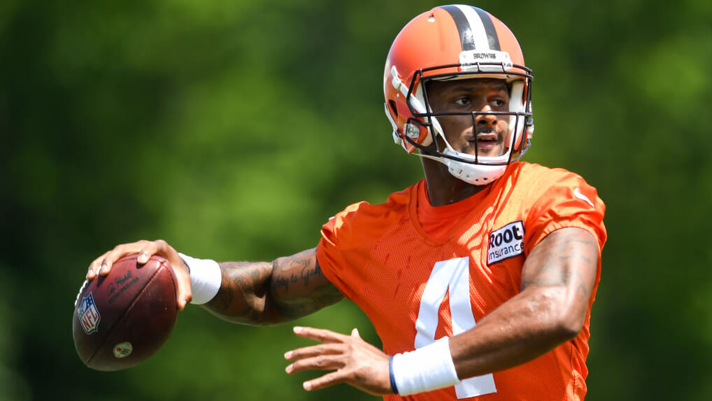 Football player Deshaun Watson of the Cleveland Browns in his orange uniform and helmet, holding a football