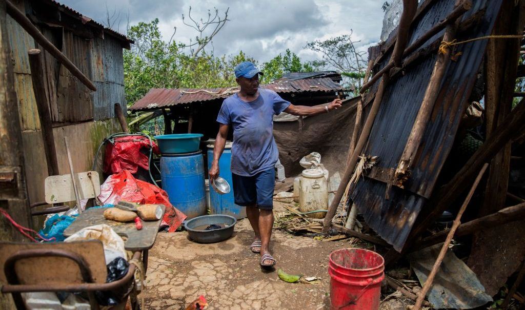 A man checks damages in a house near the highway