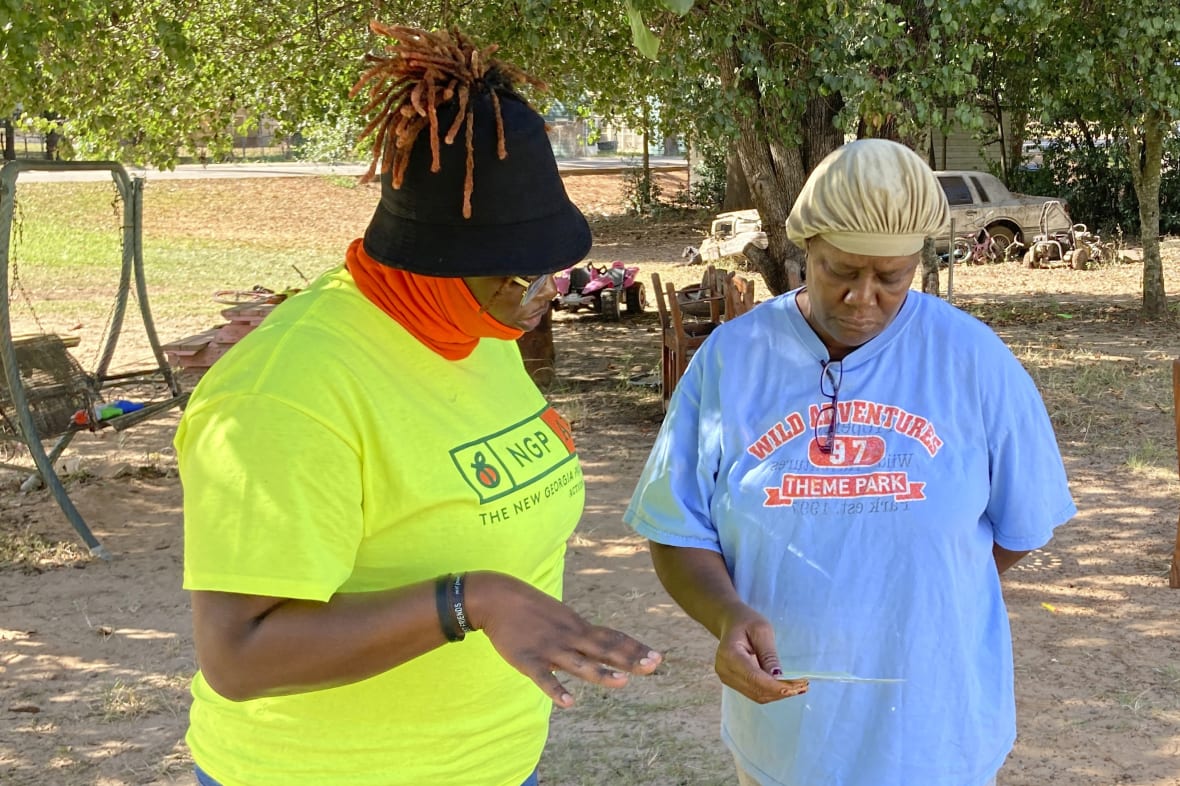 Erika Hardwick with the New Georgia Project Action Fund shares literature with Patricia Lee