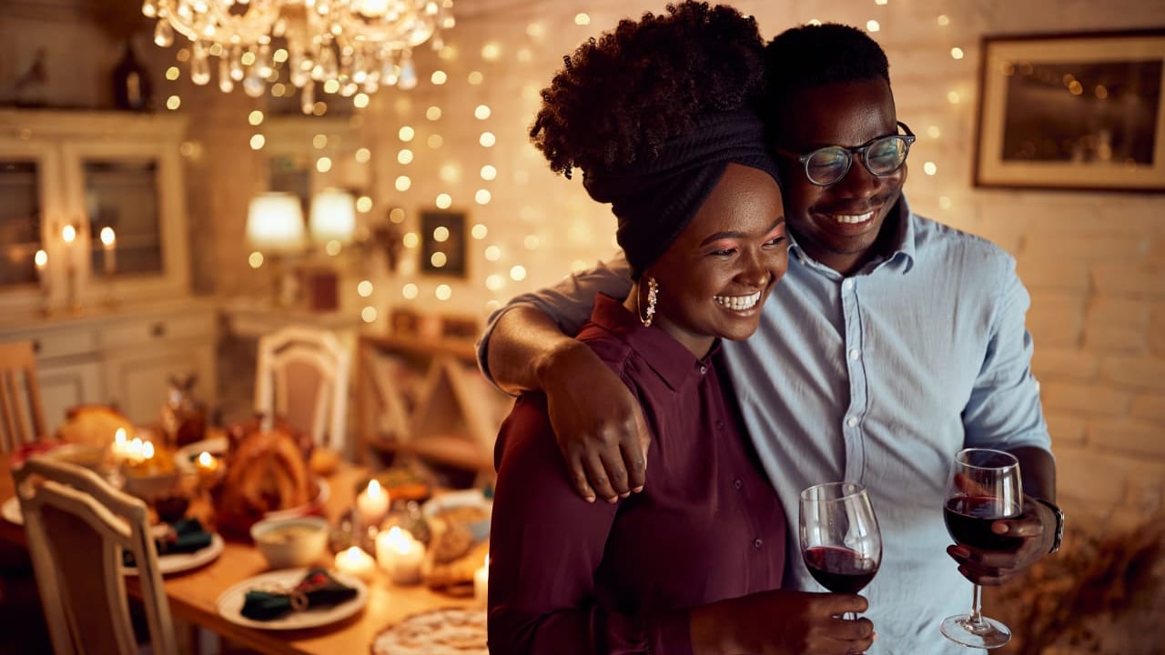 A smiling couple holding glasses of wine