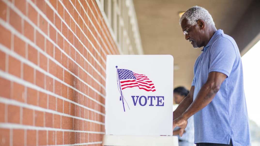 A man stands at a voting booth