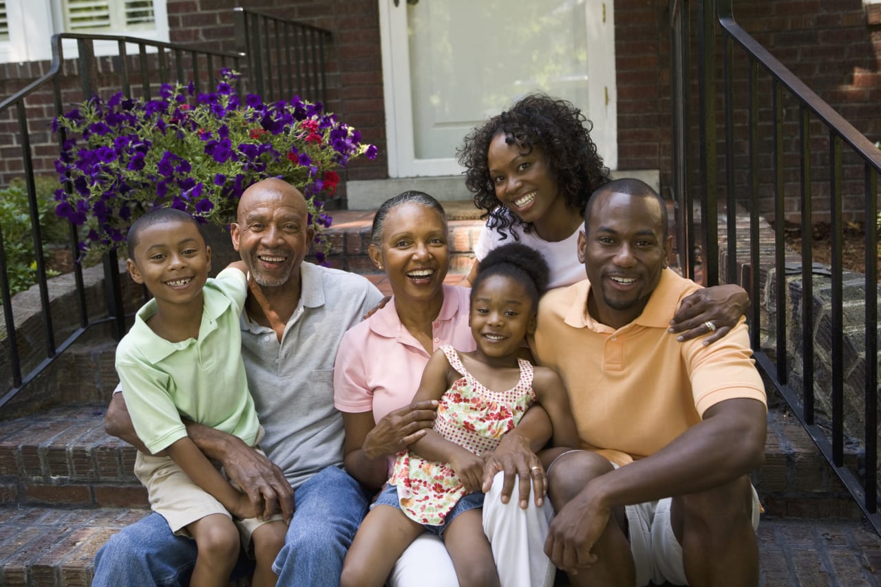 A family sits on the steps of a house