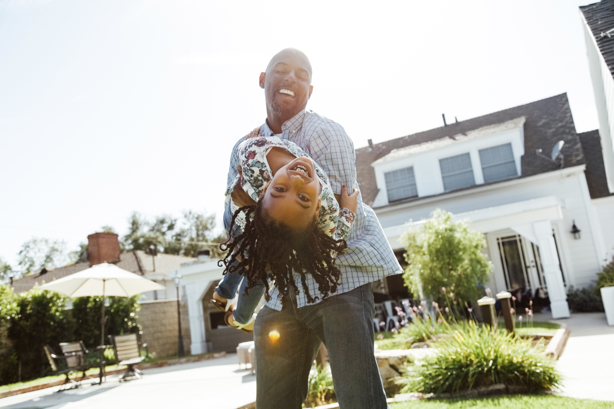 A man holds a young girl as she leans backwards