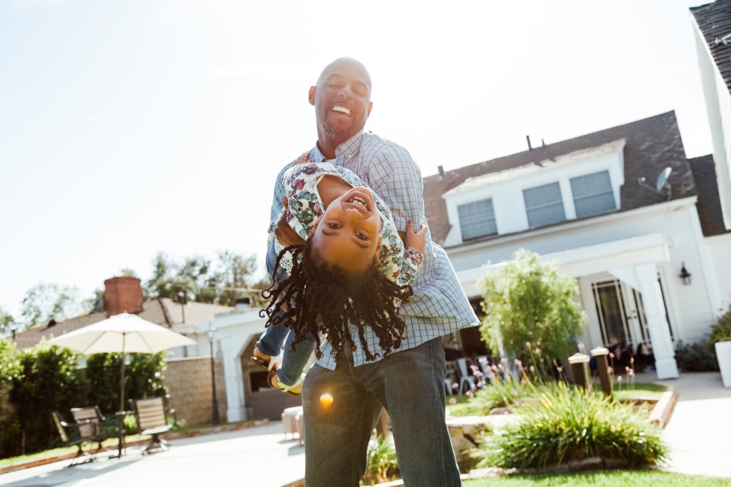 A man holds a young girl as she leans backwards