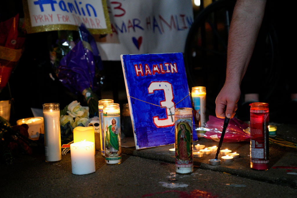 A memorial for Buffalo Bills safety Damar Hamlin showing candles and a plaque