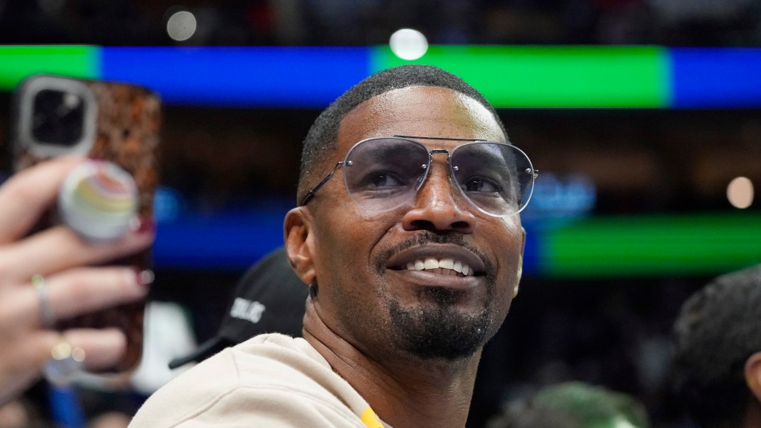 Actor Jamie Foxx wearing a white top and sunglasses