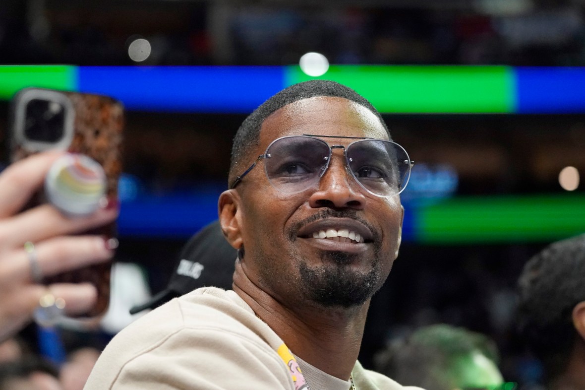 Actor Jamie Foxx wearing a white top and sunglasses