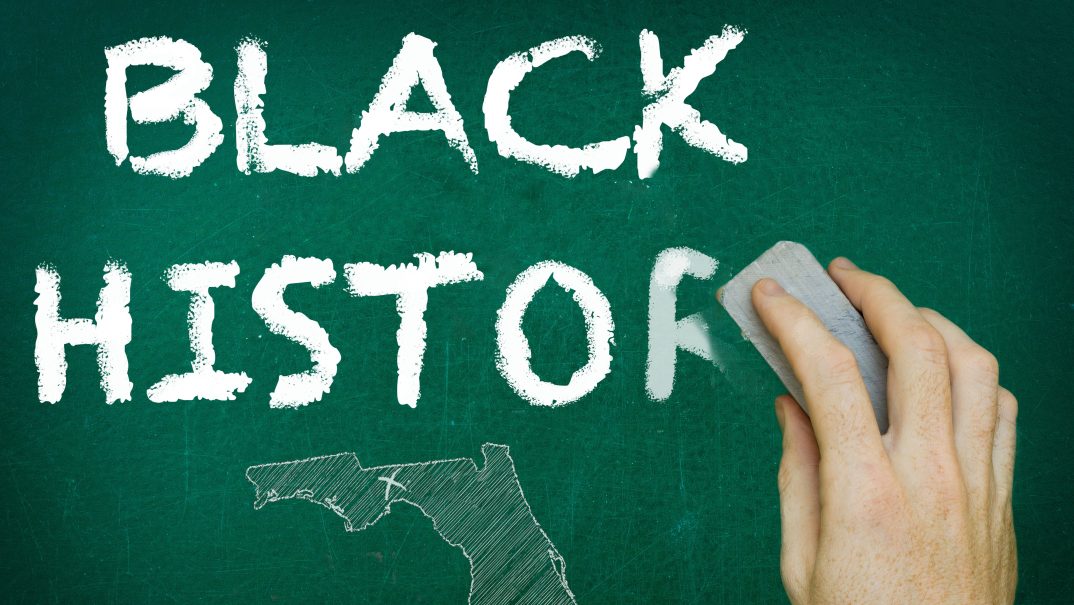 A chalkboard with the words "Black History" being erased above a map of Florida