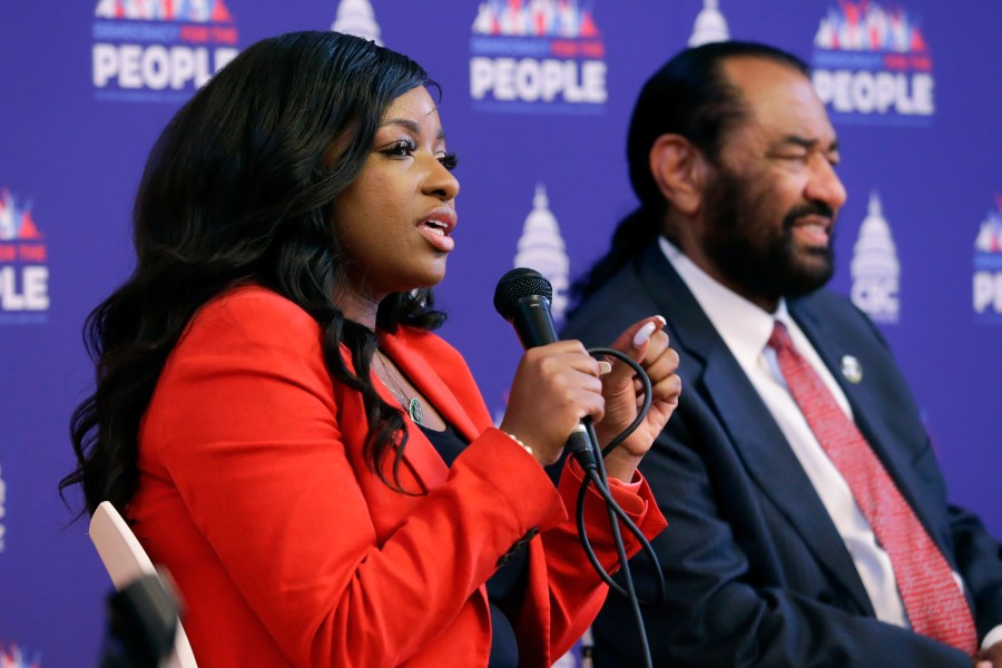 Rep. Jasmine Crockett, D-Texas, left, speaks as Rep. Al Green, D-Texas, listens during a stop of the "Democracy for the People" tour, a race and democracy summit sponsored by the Congressional Black Caucus, Wednesday, July 28, 2023, in Houston. (AP Photo/Michael Wyke)