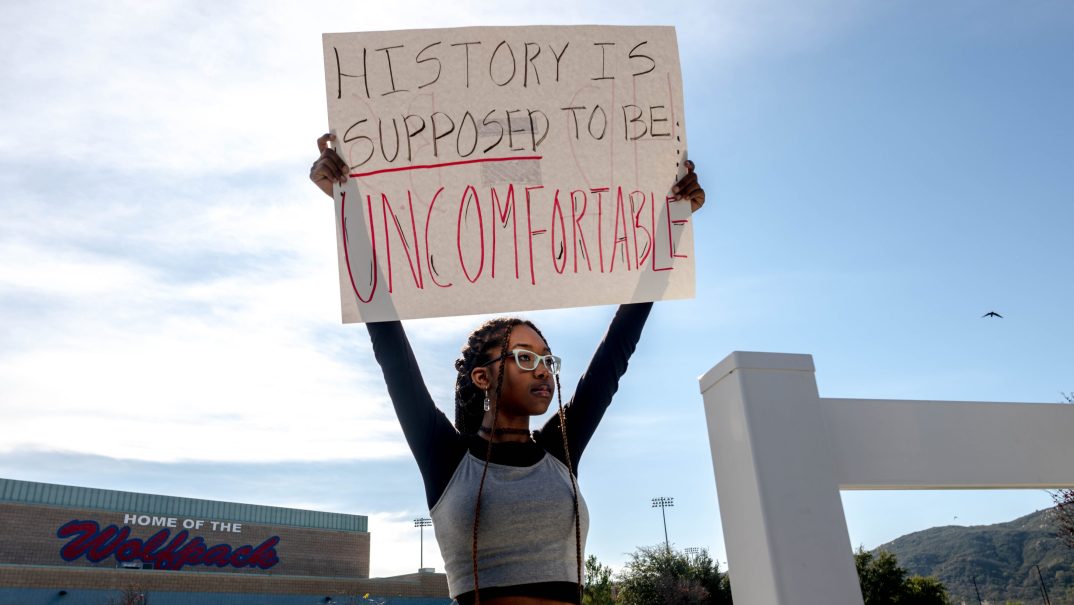 Student Samaya Robinson holds a sign in protest of the district's ban of critical race theory curriculum