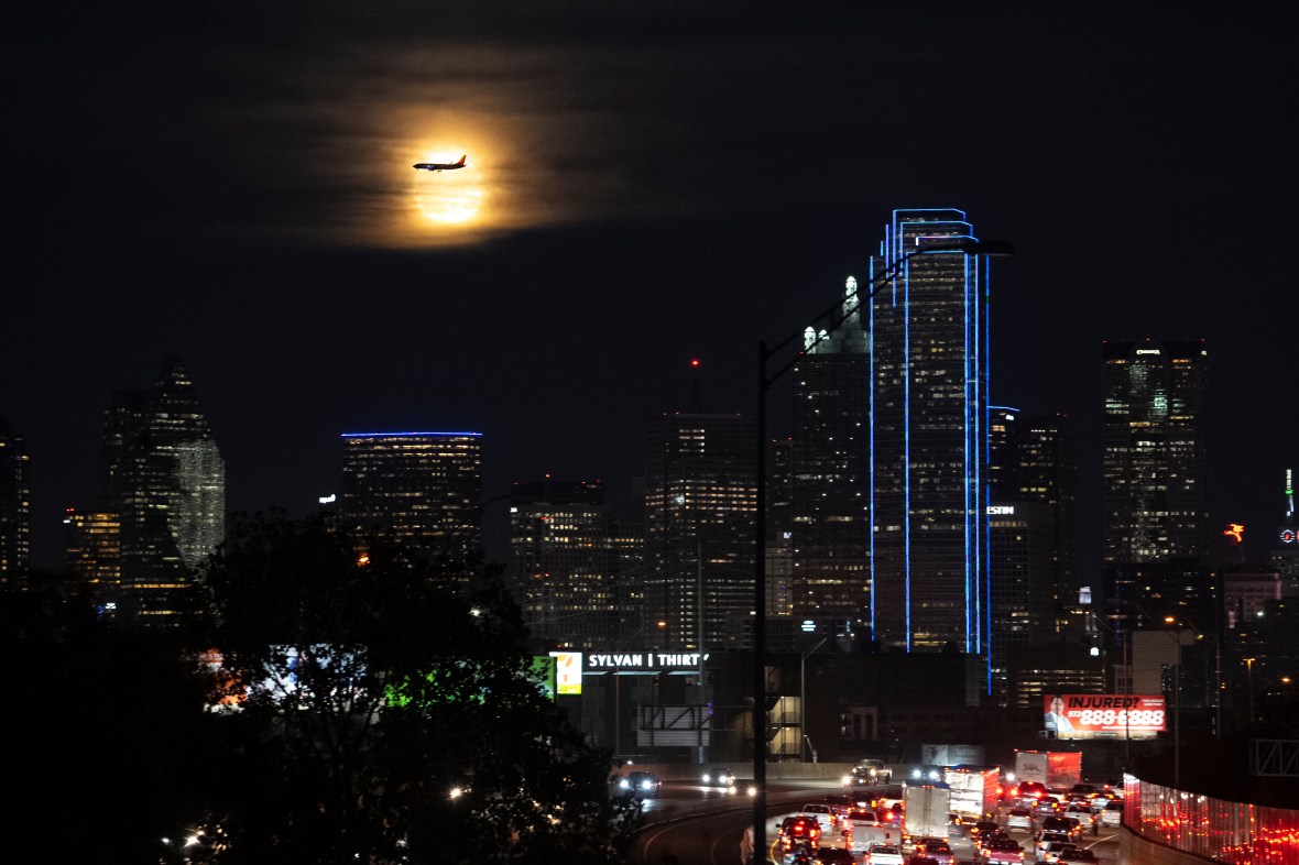 A Southwest Airlines plane makes its final approach at Dallas Love Field Airport near a the full moon