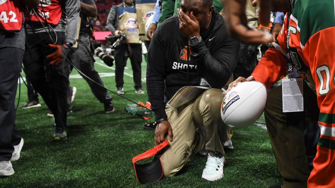 Florida A&M Head Coach Willie Simmons kneels on the ground