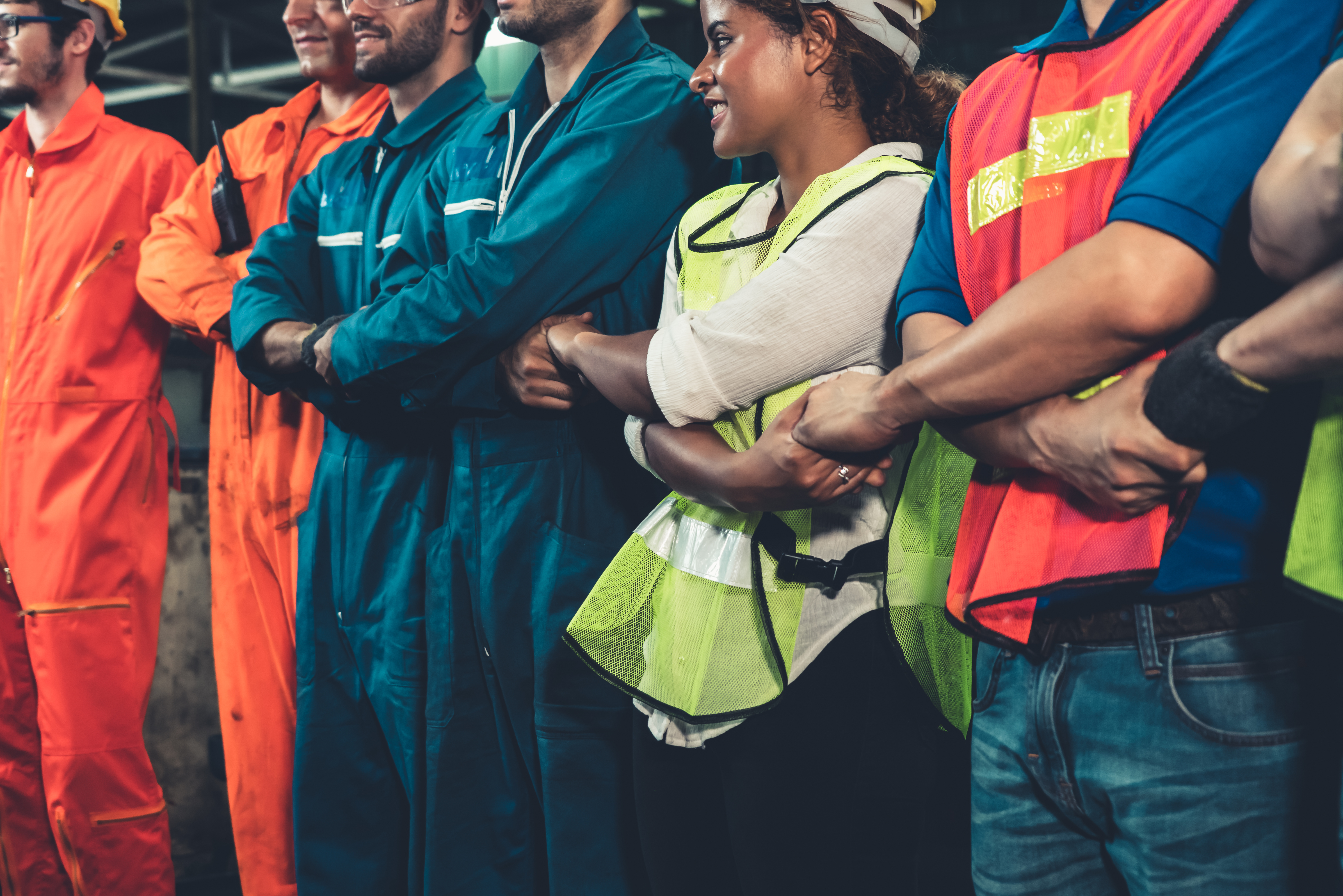 A group of workers with arms crossed holding hands