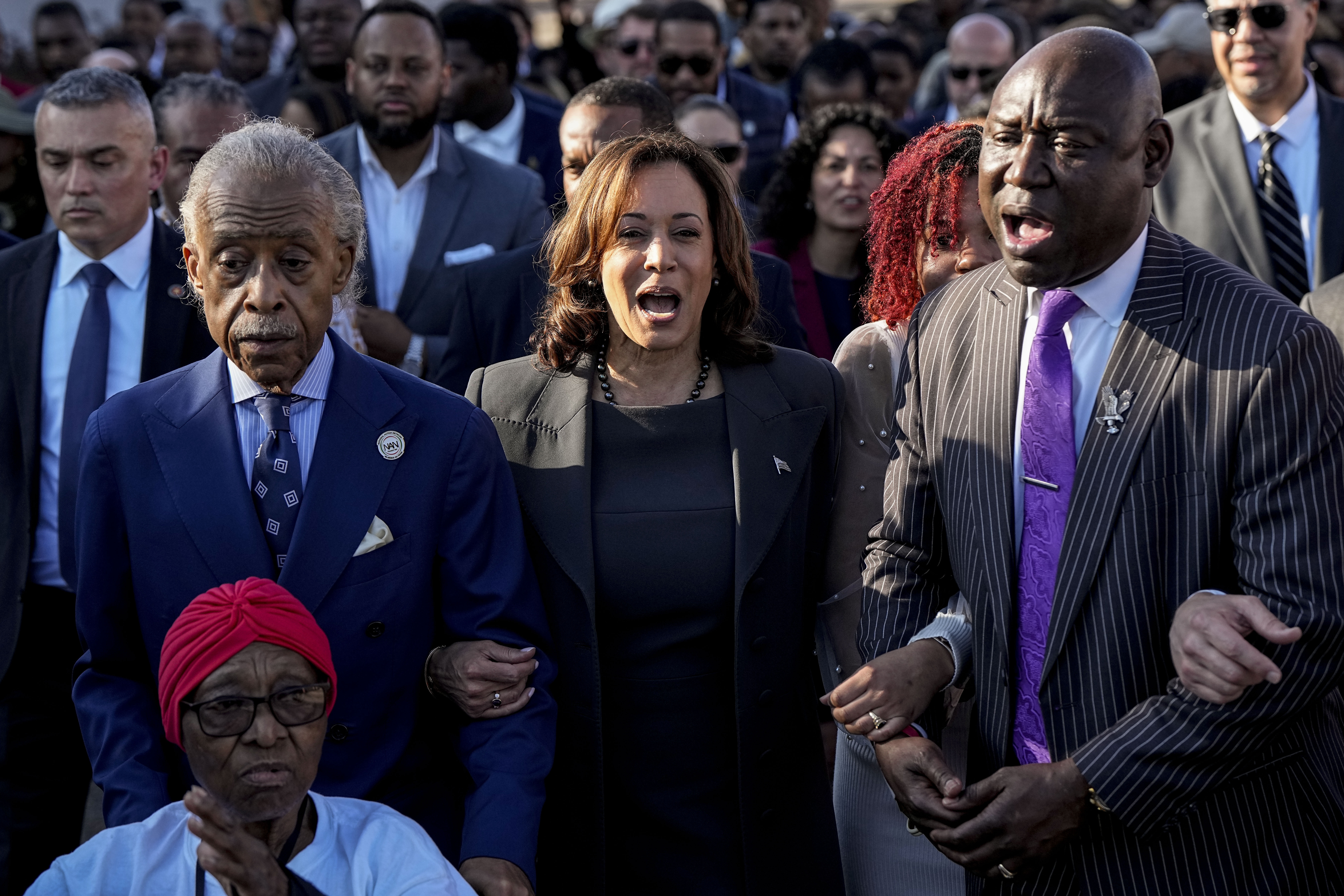 The Rev. Al Sharpton, Vice President Kamala Harris and Attorney Ben Crump walk and sing across the Edmund Pettus Bridge