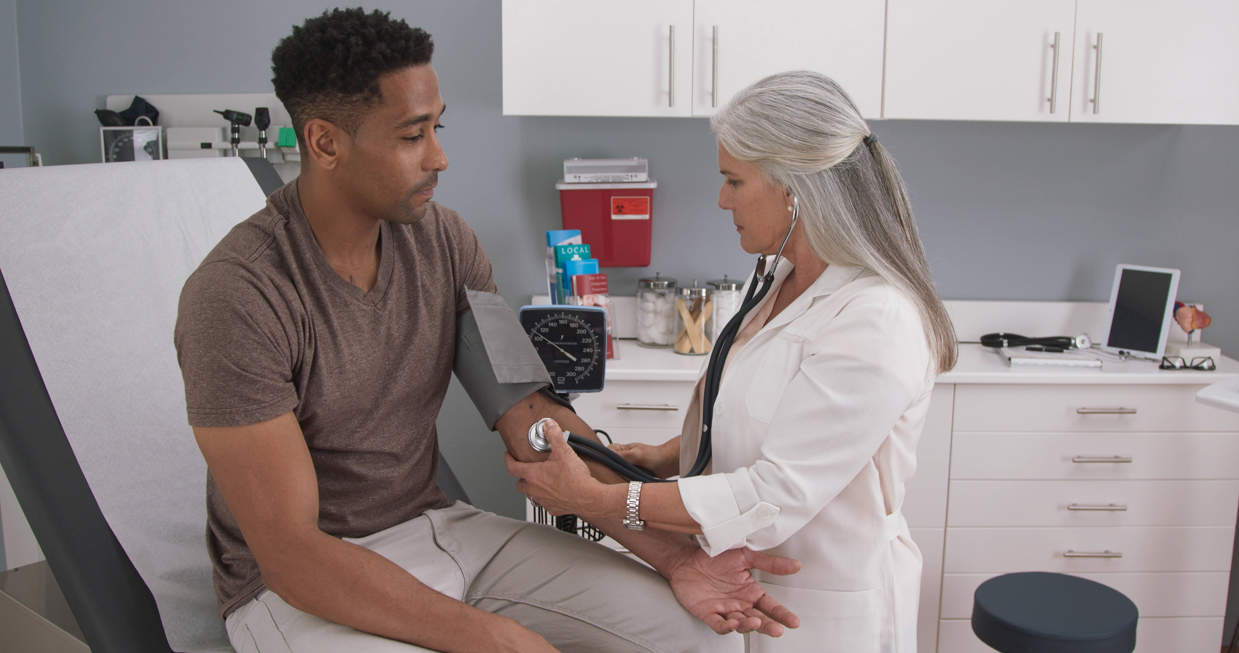 A doctor takes a man's blood pressure