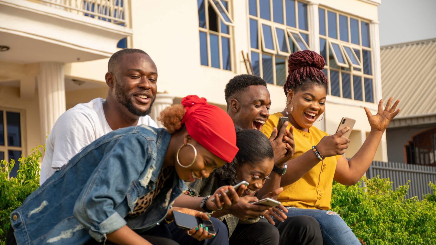 A group of people looking at their cell phones and laughing