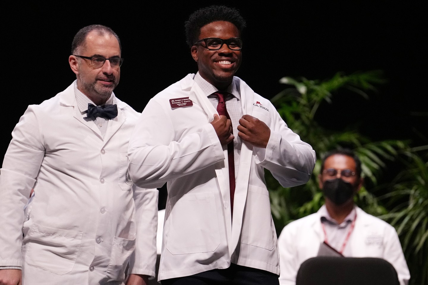 Medical student Benjamin Owens smiles as he gets his white coat from Dr. Nersi Nikakhtar