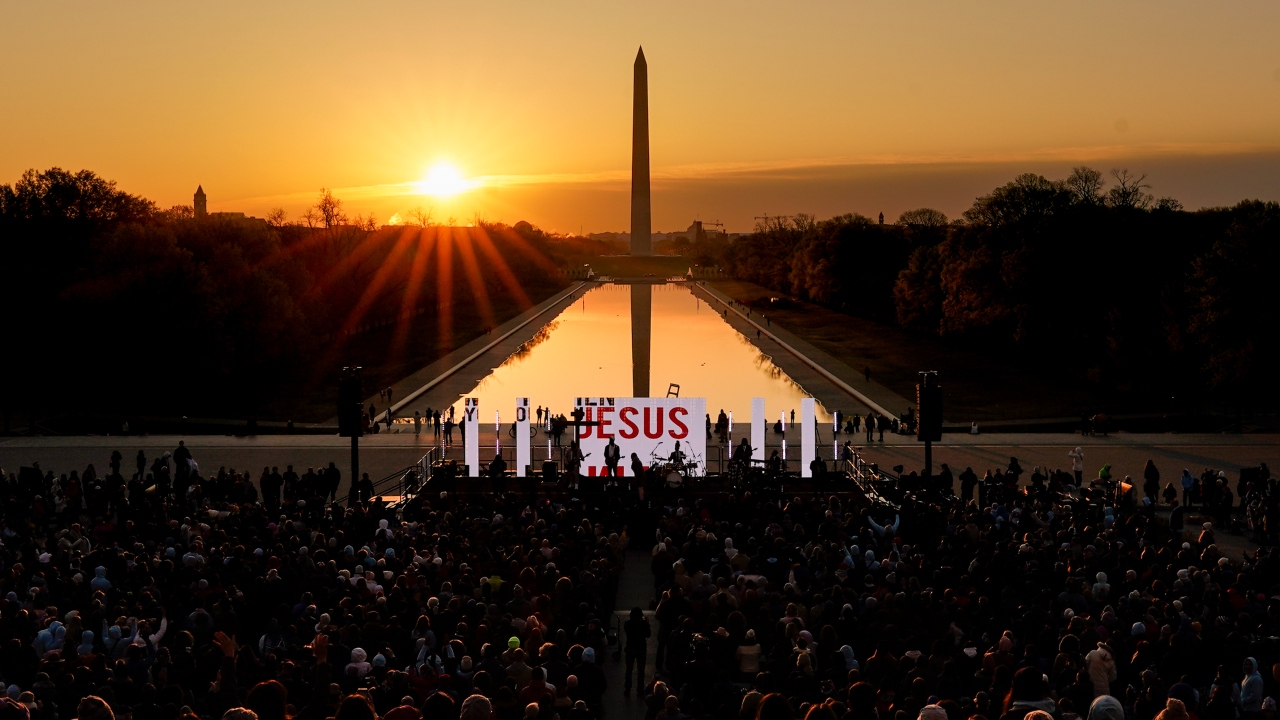 The word "Jesus" is displayed on a large monitor at an Easter sunrise service