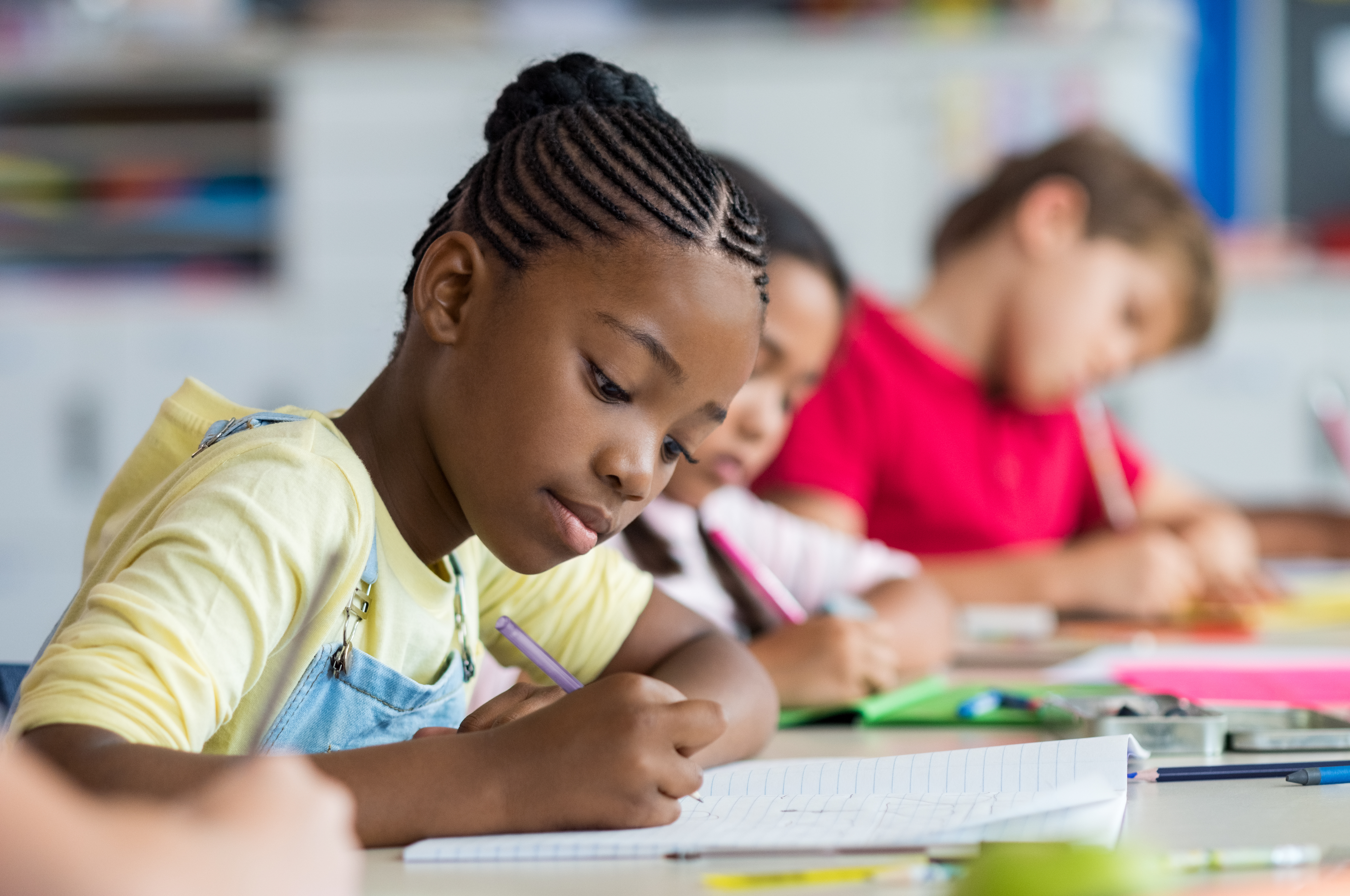 Children in a classroom writing on paper