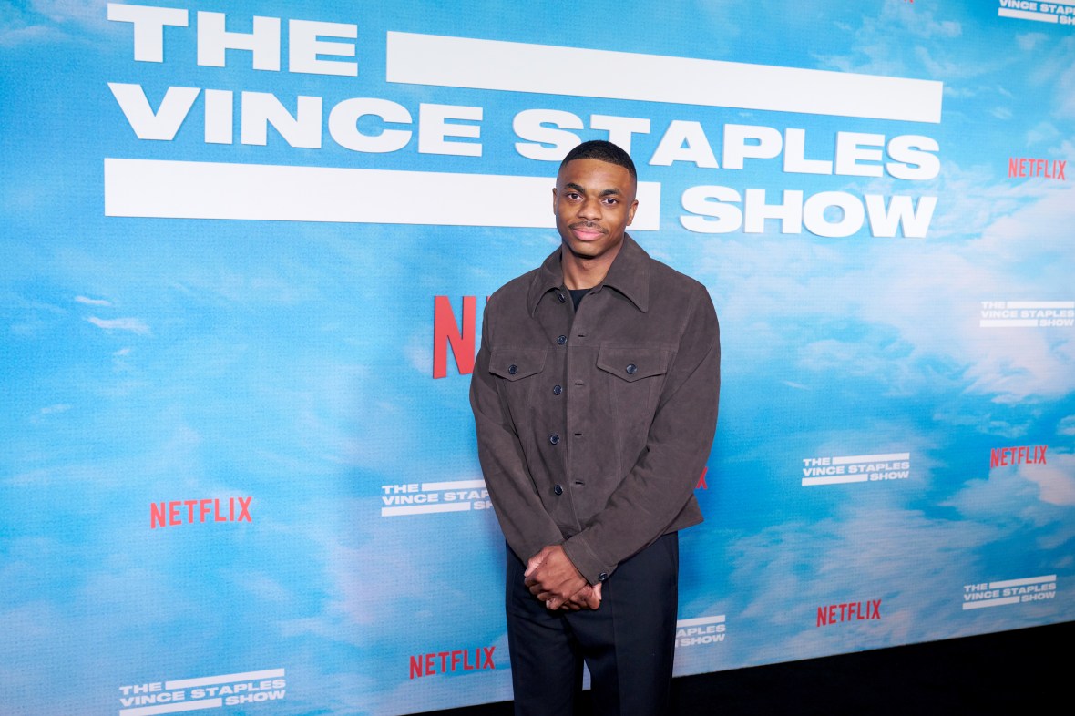 Rapper Vince Staples wearing a gray shirt and navy pants