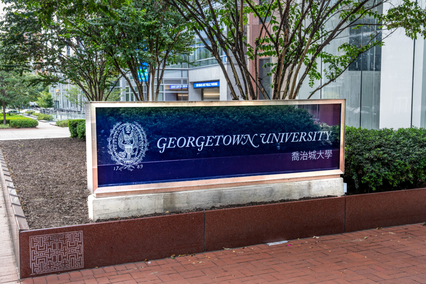 Washington, DC – Sept. 5, 2022: Georgetown University School of Continuing Studies sign with Chinese text Georgetown lost burial ground, Georgetown Forgotten Children Initiative, Maryland abandoned graveyard thegrio.com