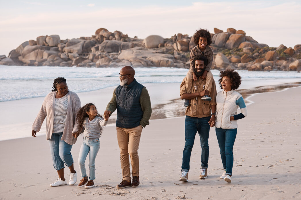 Shot of an adorable little boy and girl having a fun day at the beach with their parents and grandparents